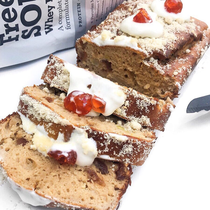 A loaf of cake topped with cherries in front of Free Soul protein