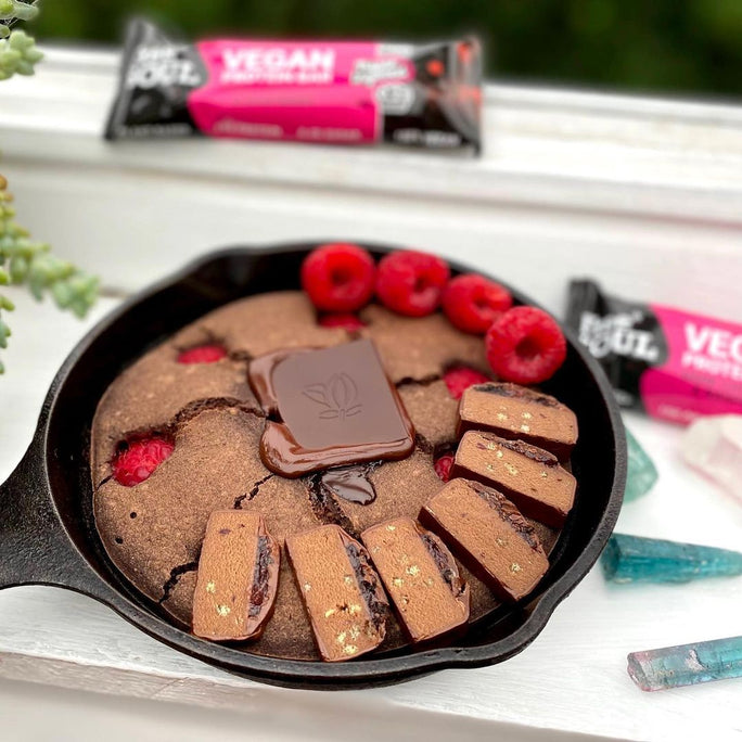 Black skillet filled with a chocolate dessert topped with Free Soul protein bars