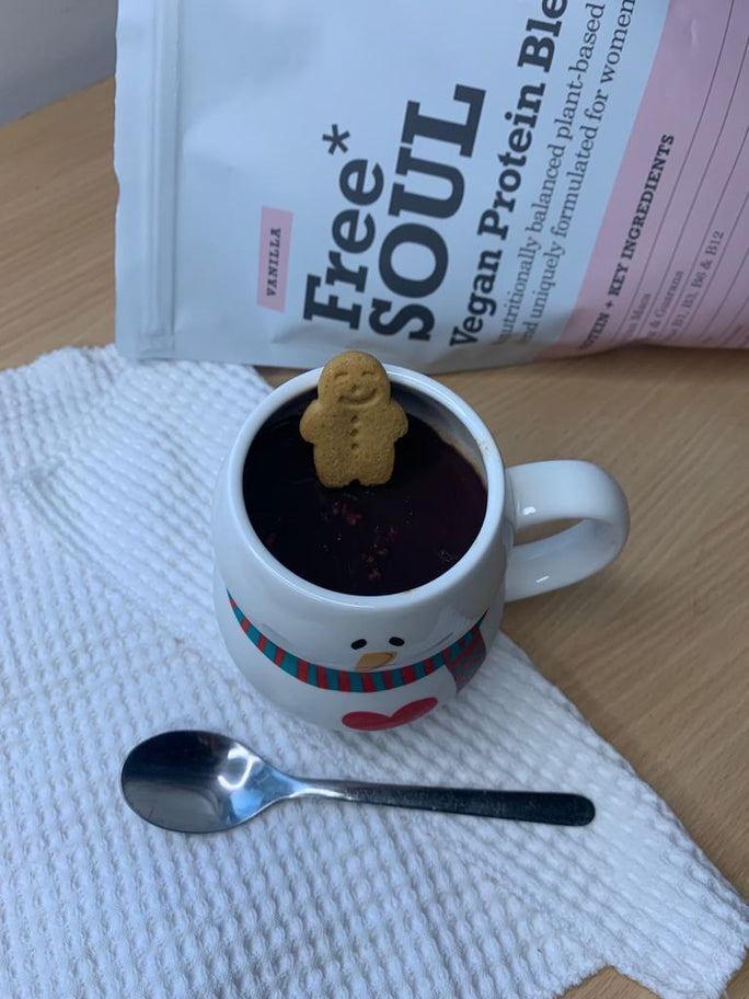 A miniture gingerbread man in a snowball mug on a white kitchen towel