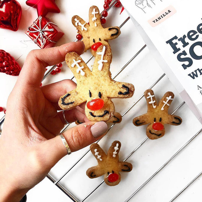 Cookies in the shape of reindeers with a bright red cherry nose