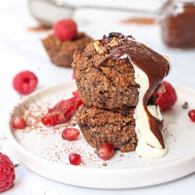 Baked muffins covered in cream, chocolate and fruits