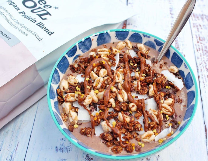 Chocolate smoothie bowl with nuts, wheat puffer and a silver spoon