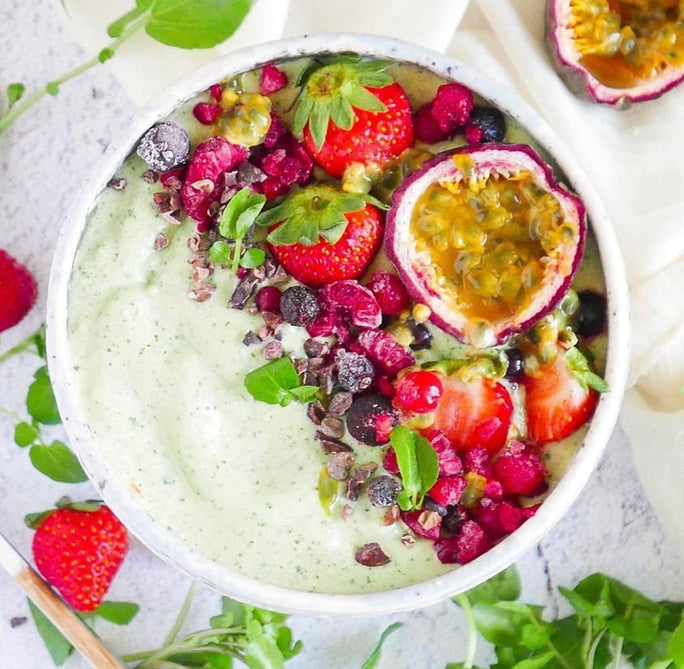 Green smoothie bowl with fresh passionfuit, blueberries, strawberries and cress