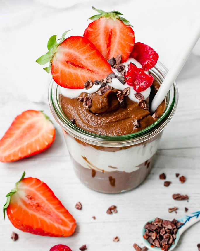 Pudding in a glass topped strawberries, raspberries and chocolate nibbles