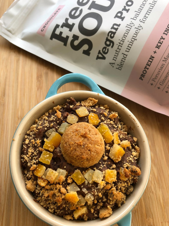 A blue baking dish filled with chocolate oats, orange cubes and a protein ball