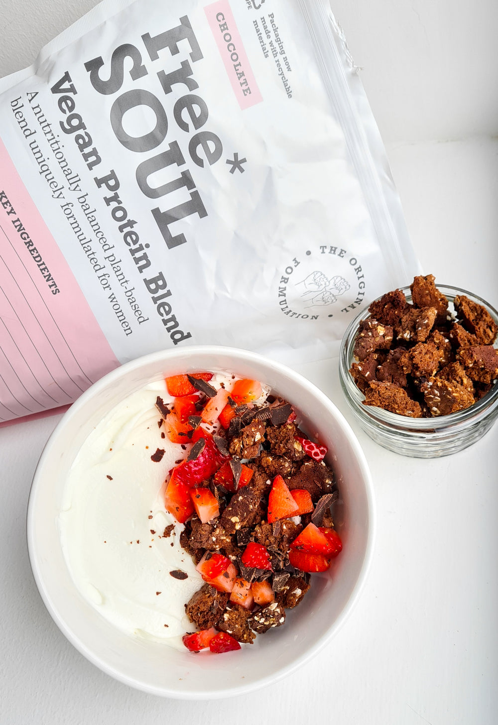 A white bowl next to a bag of Free Soul protein