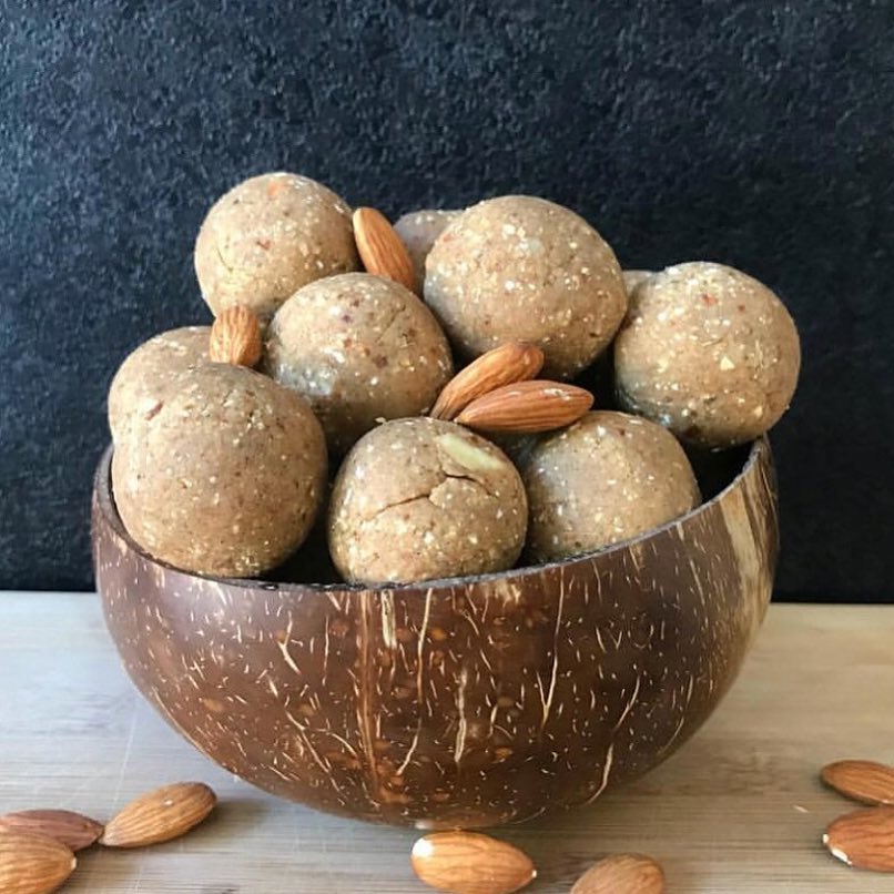 Coconut bowl filled with protein balls and whole almonds