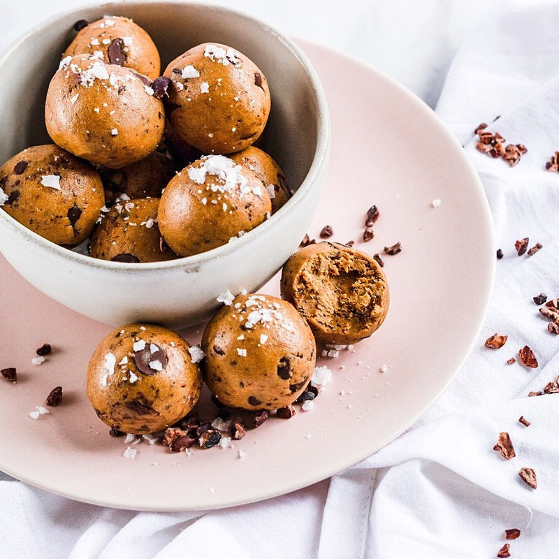 Light brown protein balls topped with chocolate shavings and sea salt