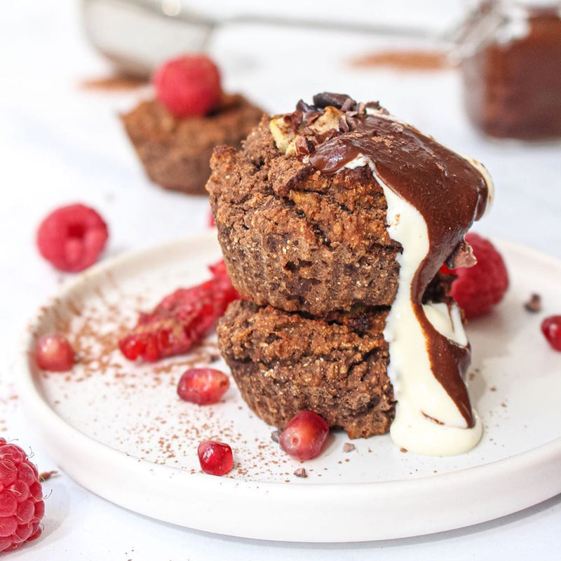 Baked muffins covered in cream, chocolate and fruits