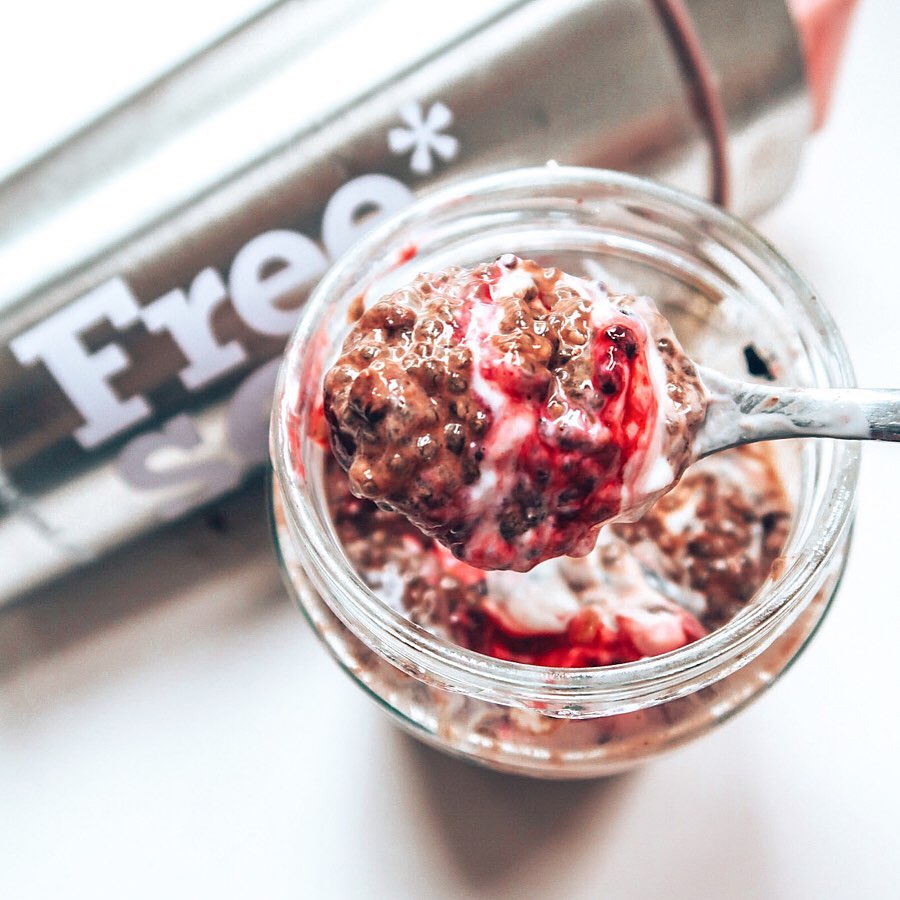 A glass of chocolate chai pudding in front of a silver Free Soul bottle