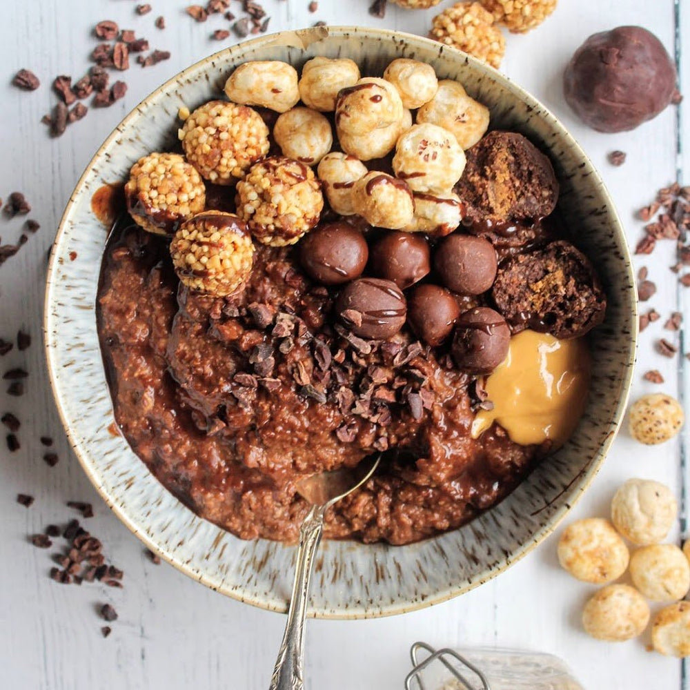 Chocolate porride oats topped with protein balls, chocolate shavings and peanut butter