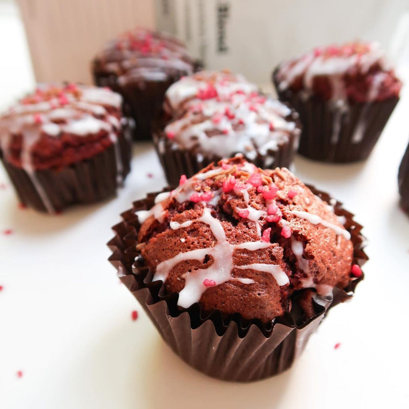 Chocolate cupcakes with white icing and pink toppings