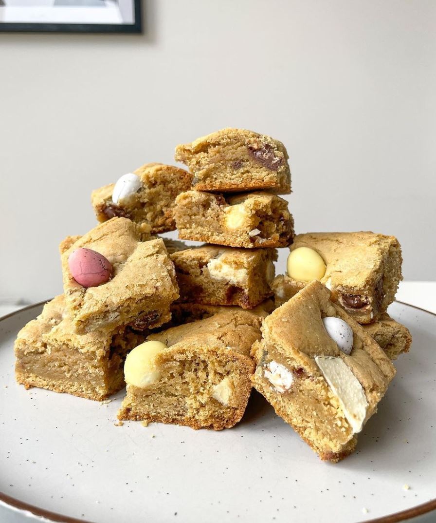 White chocolate protein brownies cut into square topped with chocolate eggs