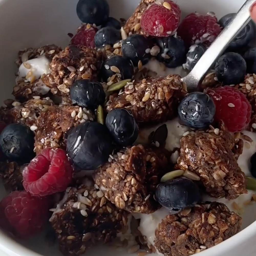 Bowl of protein cereal clusters with raspberries and blueberries