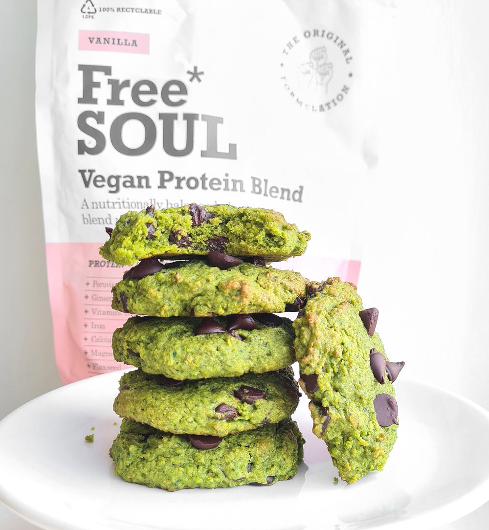 a stack of spinach protein cookies in front of a free soul vegan protein blend bag 