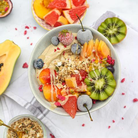 Smoothie bowl topped with cherries, kiwis and papaya