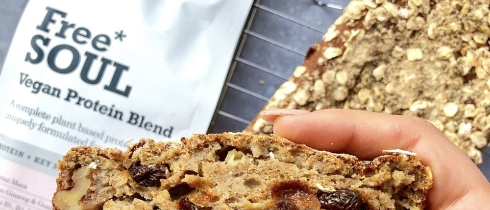A close up of a hand holding a loaf filled with nuts, raising and oats