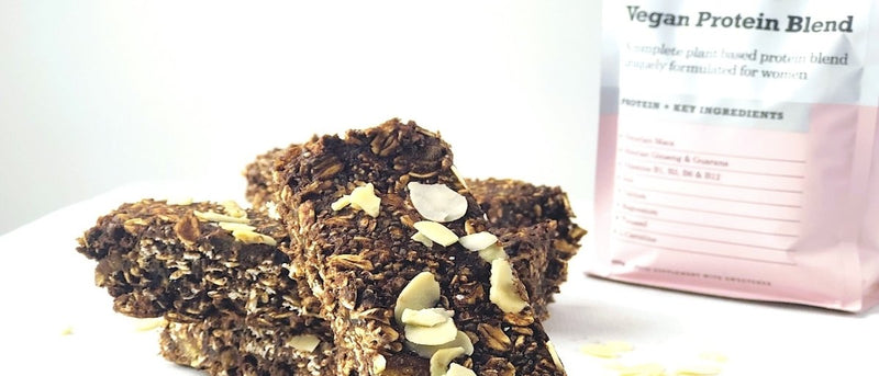 Three flapjack slices in front of vegan protein blend packaging