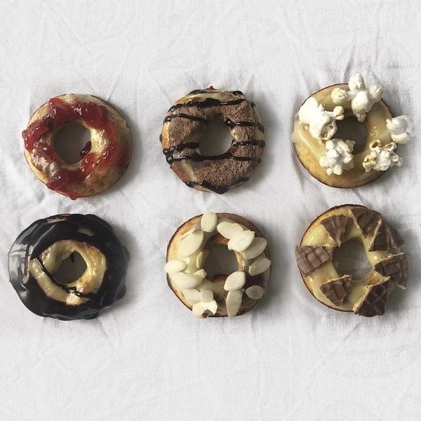 Miniture donuts topped with jam, chocolate, almonds, popcorn and more