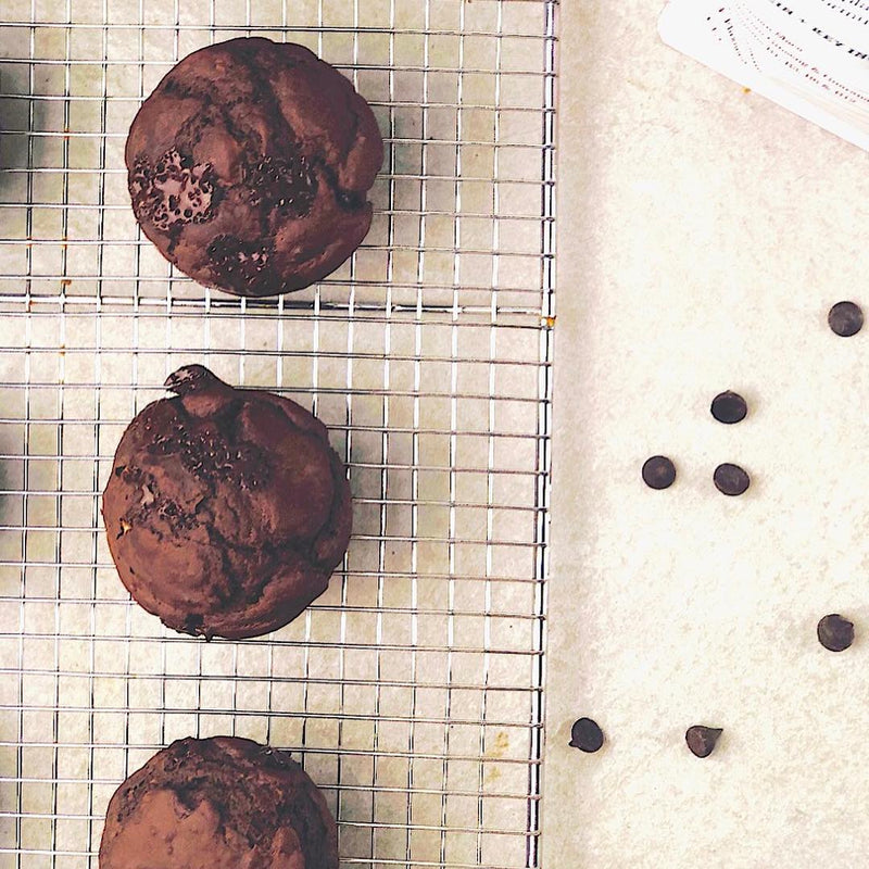 Chocolate cookies on a baking tray next to Free Soul protein powder