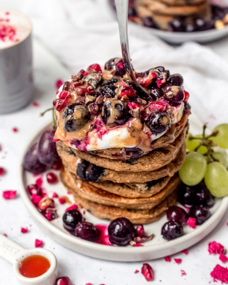 Pancakes with cherries, pomegranate seeds and syrup on top
