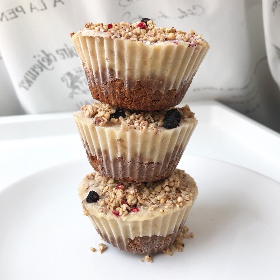 A stack of deserts with a biscuit bottom, cream-coloured top and crushed nuts topping