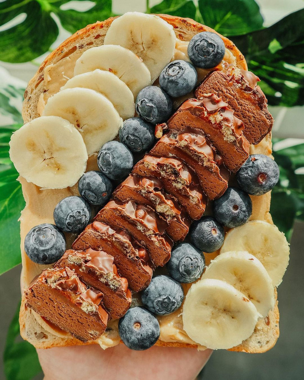 Peanut butter on toast topped with blueberries, bananas, and a Free Soul protein bar