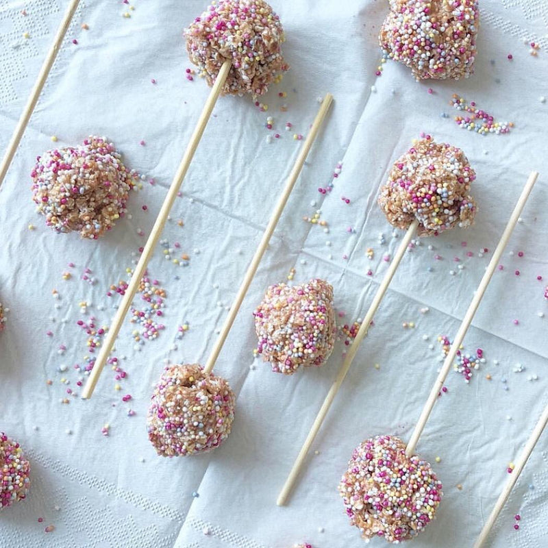 Vanilla protein balls topped with hundreds and thousands on wooden sticks