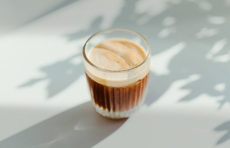 A glass of choffee in front of a white background