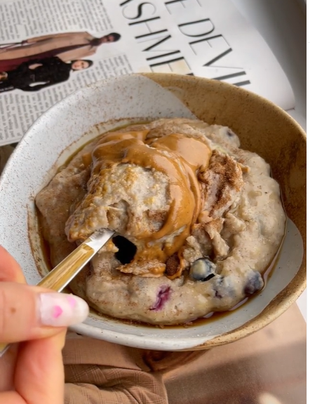 A bowl of delicious oats topped with peanut butter and berries