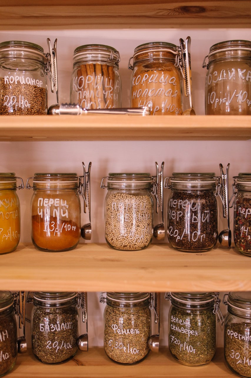 Shelves of glass jars filled with beans, lentils and spices